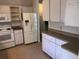 Functional kitchen featuring a refrigerator, tiled floors and white cabinetry, providing ample storage and functionality at 9896 Sw 61St Ct, Ocala, FL 34476