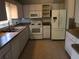 Well-lit kitchen featuring white cabinets, appliances, and tiled floors for a clean and functional space at 9896 Sw 61St Ct, Ocala, FL 34476