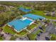 Aerial view showcasing community pools and lush landscaping nestled near a tranquil lake and golf course at 10824 Sw 90Th Ter, Ocala, FL 34481