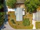 Birds eye view of the property with a grey roof, long driveway and mature trees surrounding the house at 10824 Sw 90Th Ter, Ocala, FL 34481