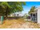 Backyard with mature trees, partial fencing, and view of screen room attached to the house at 10824 Sw 90Th Ter, Ocala, FL 34481