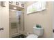 Bathroom featuring a glass-enclosed shower, toilet, and a small window allowing natural light at 10824 Sw 90Th Ter, Ocala, FL 34481