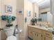Bright bathroom with a large vanity and a mirror, decorated with plants and artwork at 10824 Sw 90Th Ter, Ocala, FL 34481