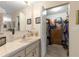Bathroom sink and mirror near a closet, featuring a vanity with marble countertop and storage at 10824 Sw 90Th Ter, Ocala, FL 34481