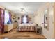 Bedroom features a wood floor, ceiling fan, dresser, and bed with a floral pattern at 10824 Sw 90Th Ter, Ocala, FL 34481