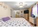 Bedroom with wood floors, ceiling fan, dresser with TV and comfortable bed with decorative pillows at 10824 Sw 90Th Ter, Ocala, FL 34481