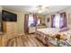 Well-lit bedroom with wood floors, dresser, TV and decorative bedding in a floral pattern at 10824 Sw 90Th Ter, Ocala, FL 34481