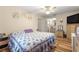 Spacious bedroom includes wood floors, ceiling fan, dresser and comfortable bed with floral pattern at 10824 Sw 90Th Ter, Ocala, FL 34481