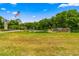 A view of the community entrance sign with the American flag set amongst lush landscaping at 10824 Sw 90Th Ter, Ocala, FL 34481