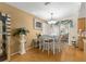 An inviting dining area with a decorative table, light fixture, and beautiful wood floors at 10824 Sw 90Th Ter, Ocala, FL 34481