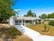 Charming single-story home with a well-manicured lawn and white driveway at 10824 Sw 90Th Ter, Ocala, FL 34481