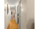 A hallway with hardwood floors, neutral-colored walls, and multiple doors at 10824 Sw 90Th Ter, Ocala, FL 34481
