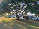 Serene view of a home with mature trees, a screened-in porch, and ample parking in a well-kept yard at 10980 Sw 63Rd Ave, Ocala, FL 34476