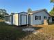 Rear view of home with white siding, window shutters, Florida room and a storage shed at 10980 Sw 63Rd Ave, Ocala, FL 34476