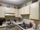 Features a stove, stainless sink and ample counter space with white cabinetry and wood trim detail at 10980 Sw 63Rd Ave, Ocala, FL 34476