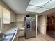 Efficient kitchen space with stainless steel refrigerator, light countertops, and ample cabinet storage at 10980 Sw 63Rd Ave, Ocala, FL 34476