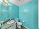 Bright bathroom featuring turquoise walls, a vanity with a sink, a large mirror, and a toilet at 1109 Ne 22Nd Ave, Ocala, FL 34470