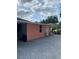 Back exterior of home featuring a paved patio area, one window, and a white door at 1109 Ne 22Nd Ave, Ocala, FL 34470