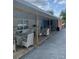 Covered outdoor patio with stylish furniture, including a white sofa and two wicker dining tables at 1109 Ne 22Nd Ave, Ocala, FL 34470
