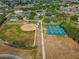 Aerial view of community baseball diamond, walking path, and blue tennis courts at 11799 Se 173Rd Lane Rd, Summerfield, FL 34491
