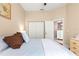 Bright bedroom with a large bed, closet, and doorway leading to a bathroom at 11799 Se 173Rd Lane Rd, Summerfield, FL 34491