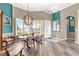 Open-concept dining area featuring an eye-catching light fixture and plenty of natural light at 11799 Se 173Rd Lane Rd, Summerfield, FL 34491
