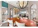 Elegant dining room with tray ceilings, modern lighting, and a view into the living room at 11799 Se 173Rd Lane Rd, Summerfield, FL 34491
