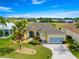Stunning exterior view of a well-maintained home with a brick driveway, lush lawn, and manicured landscaping at 11799 Se 173Rd Lane Rd, Summerfield, FL 34491