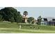 Golf course view with golfers on the green and trees and houses in the background at 11799 Se 173Rd Lane Rd, Summerfield, FL 34491