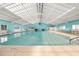 Indoor pool with clear water, bright lighting, and comfortable seating at 11799 Se 173Rd Lane Rd, Summerfield, FL 34491