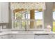 Bright kitchen featuring a window with white shutters overlooking the outdoor living area at 11799 Se 173Rd Lane Rd, Summerfield, FL 34491