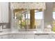 Bright kitchen features white cabinets, marble counters, and window views of the lanai and landscaped yard at 11799 Se 173Rd Lane Rd, Summerfield, FL 34491