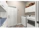 Functional laundry room with modern appliances, storage cabinets and exterior access at 11799 Se 173Rd Lane Rd, Summerfield, FL 34491