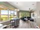 Open-concept living room with bar seating and views of a lush, green exterior landscape at 11799 Se 173Rd Lane Rd, Summerfield, FL 34491