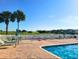 Resort-style pool area overlooking golf course with palm trees and lounge chairs at 11799 Se 173Rd Lane Rd, Summerfield, FL 34491