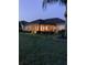 Back of house featuring a screened lanai overlooking the yard at dusk at 11799 Se 173Rd Lane Rd, Summerfield, FL 34491