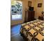 Bedroom featuring a patterned quilt, dresser, and a window with a unique curtain at 14 Se 62Nd Ter, Ocala, FL 34471