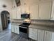 Kitchen with stainless steel appliances, light colored cabinets and stone countertops at 14 Se 62Nd Ter, Ocala, FL 34471