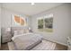 Bright bedroom with neutral tones, plush rug, and large window providing a scenic outdoor view at 15769 Sw 37Th Cir, Ocala, FL 34473