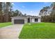 Charming single-story home featuring a well-manicured lawn and a two-car garage with stone accents at 15769 Sw 37Th Cir, Ocala, FL 34473