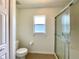 Bathroom features a toilet, window, and tiled shower stall at 15782 Sw 16Th Avenue Rd, Ocala, FL 34473