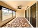 Enclosed lanai with ceiling fan and brick-patterned floor tiles, bathed in sunlight at 15782 Sw 16Th Avenue Rd, Ocala, FL 34473