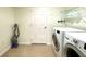Bright laundry room features a white washer and dryer, tile floor, and shelving at 15782 Sw 16Th Avenue Rd, Ocala, FL 34473
