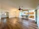 Open-concept living room with hardwood floors and bar, featuring a ceiling fan and sliding glass doors at 15782 Sw 16Th Avenue Rd, Ocala, FL 34473