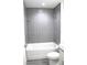 Bathroom with tiled shower-tub, featuring sleek gray tile and glass shelf at 20 Malauka Pass Crse, Ocklawaha, FL 32179