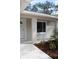Close-up of a home's front door and window, complemented by garden beds at 20 Malauka Pass Crse, Ocklawaha, FL 32179