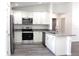 Well-lit kitchen featuring white cabinets, granite countertops, stainless steel appliances, and wood-look flooring at 20 Malauka Pass Crse, Ocklawaha, FL 32179