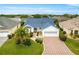 Inviting home with a paver driveway, manicured landscaping, and a pristine blue roof at 2087 Bonneau Ln, The Villages, FL 32162