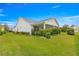 Lush backyard featuring a well-manicured lawn, green hedges, and a screened-in porch at 2087 Bonneau Ln, The Villages, FL 32162