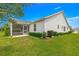 Landscaped backyard with healthy green lawn, trimmed hedges, and screened lanai at 2087 Bonneau Ln, The Villages, FL 32162